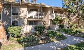 an apartment building with a sidewalk in front of it  at Alosta Place, Azusa, CA
