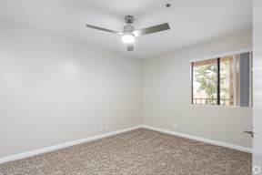 an empty room with a ceiling fan and a window at Huntington Terrace North Senior, Huntington Beach, CA 92648