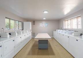 an empty kitchen with white cabinets and a table at North View Terrace, Montebello, CA