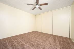 a bedroom with white walls and a ceiling fan at Villa Hemet, Hemet California