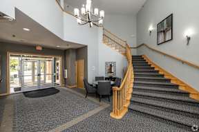 A staircase with a yellow railing and a grey carpet.