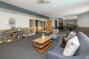 A living room with a grey couch and a wooden coffee table.