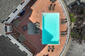 A swimming pool surrounded by lounge chairs and umbrellas.