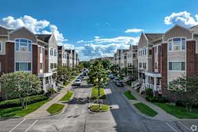 A street view of a residential area with cars parked on the side of the road.