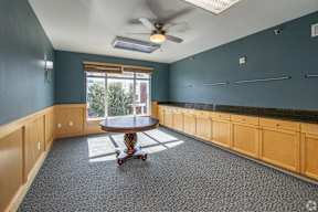 A room with a round table and a ceiling fan.