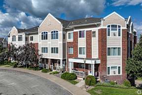 A large apartment building with a parking lot in front.