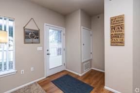 A room with a wooden floor and a sign on the wall.