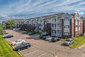 A parking lot in front of apartment buildings.