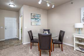 A dining room with a glass table and chairs.