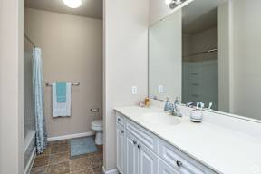 A bathroom with a white sink and a white toilet.