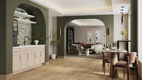 A modern kitchen with a dining area in the background.