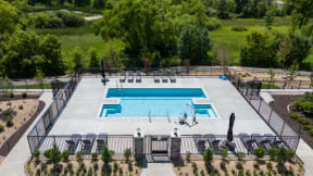 an aerial view of a swimming pool with chairs around it