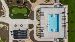 arial view of a swimming pool and a grassy area with umbrellas