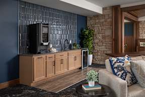 A modern living room with a stone wall and a wooden cabinet.
