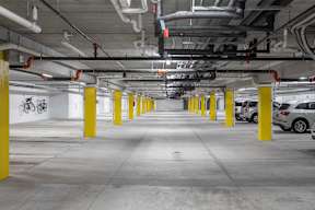 A parking garage with yellow poles and white walls.