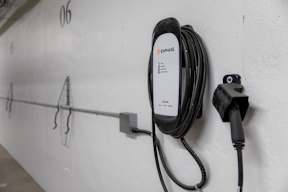 An EV charging cable plugged into a wall socket.