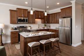 A kitchen with wooden cabinets and a stainless steel refrigerator.