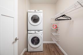 A white laundry room with a washer and dryer stacked on top of each other.