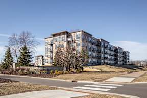 A large apartment complex with a crosswalk in front of it.