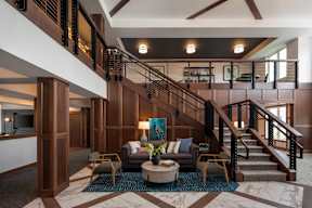 the lobby of a hotel with a staircase and a couch