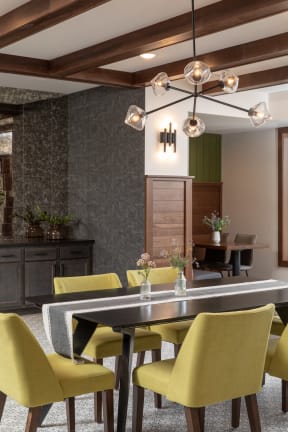 a dining room with a black table and yellow chairs