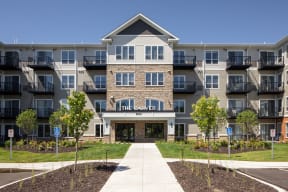an apartment building with a sidewalk in front of it