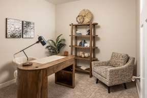 A room with a desk, chair, and bookshelf.
