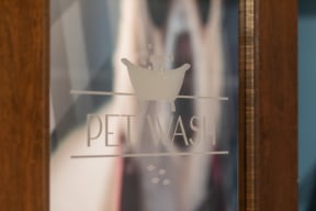 the logo of pet wash is shown on a glass door