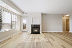a spacious living room with a fireplace and a large window