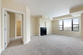 an empty living room with a fireplace and a large window