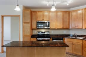a kitchen with wooden cabinets and granite counter tops