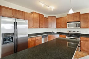 a kitchen with granite countertops and wooden cabinets