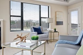 a living room with a couch and a chair near a large window