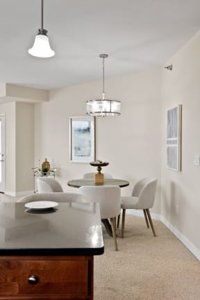 a dining area with a table and chairs and a chandelier above