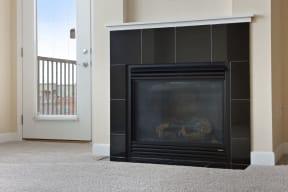 a fireplace with a black tile surround in a living room