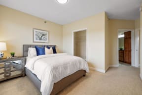 a bedroom with a large bed and a dresser next to it