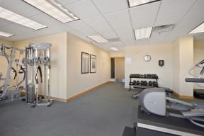 a fitness room with cardio equipment and weights