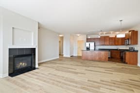 a living room with a fireplace and a view of the kitchen