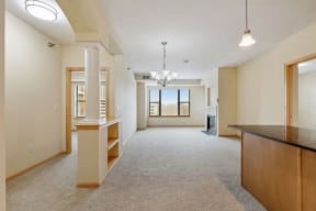 a view of an empty living room with a counter and a chandelier