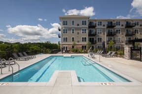a swimming pool with an apartment building in the background