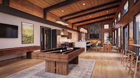 A billiard table is in the middle of a room with a wooden floor and ceiling.