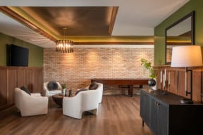 a living room with furniture and a brick wall