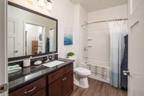 a bathroom with a large mirror and a toilet and shower