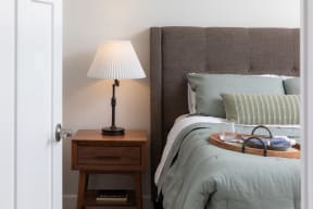 a bedroom with a bed and a nightstand with a lamp