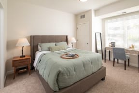 a bedroom with a large bed and a desk with a chair