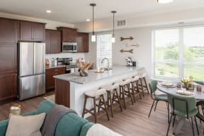 a kitchen with a large island and a dining table with chairs