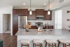 a kitchen with wooden cabinets and a marble counter top