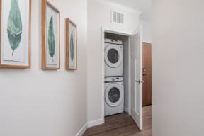 a washer and dryer in a hallway with a door to a laundry room