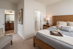 a bedroom with a bed and a dresser and a bathroom