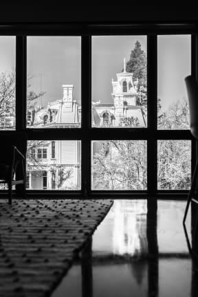 a black and white photo of a large house through a window